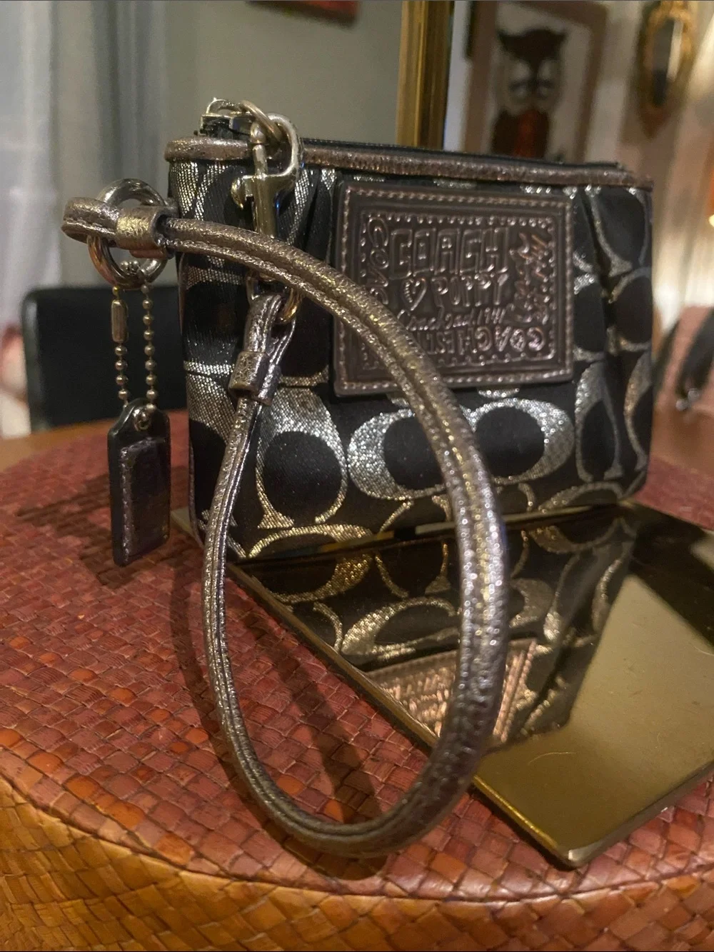 Coach Poppy wristlet black and silver monogram fabric with silver logo plaque.